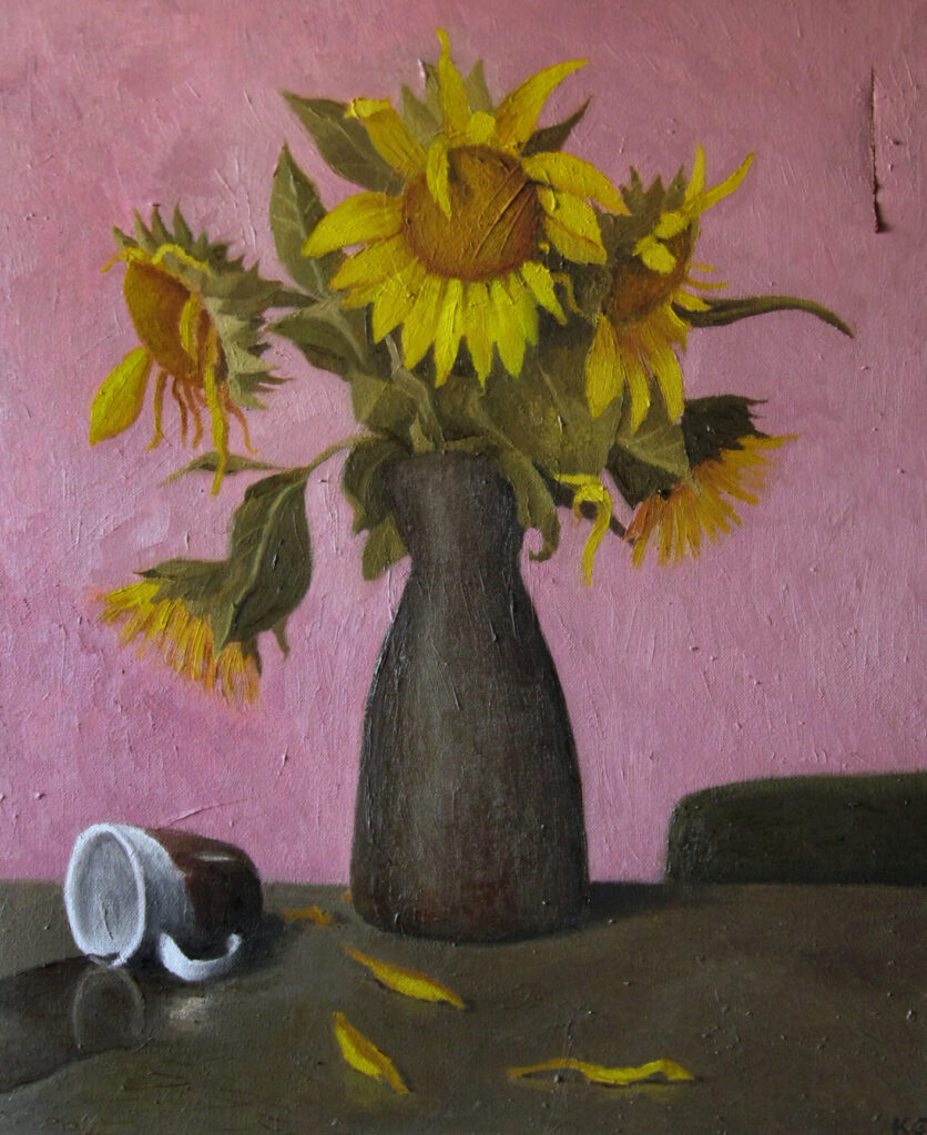 verwelkende Sonnenblumen vor einer rosa Wand mit einem Riss 